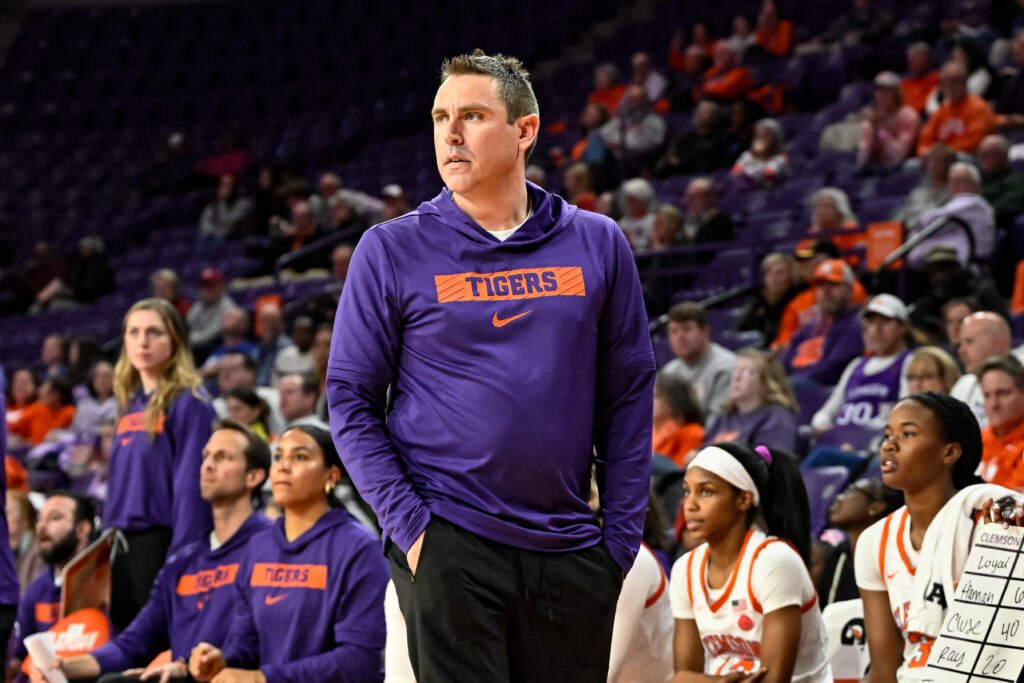 Basketball Coach in purple hoodie with Tigers and nike check in orange.